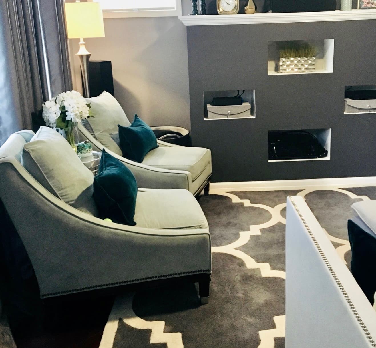Close view of the built-in media wall niches with accent chairs alongside