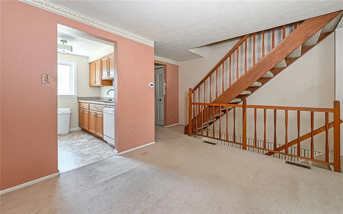 Original carpeted stairs and dated kitchen before remodel