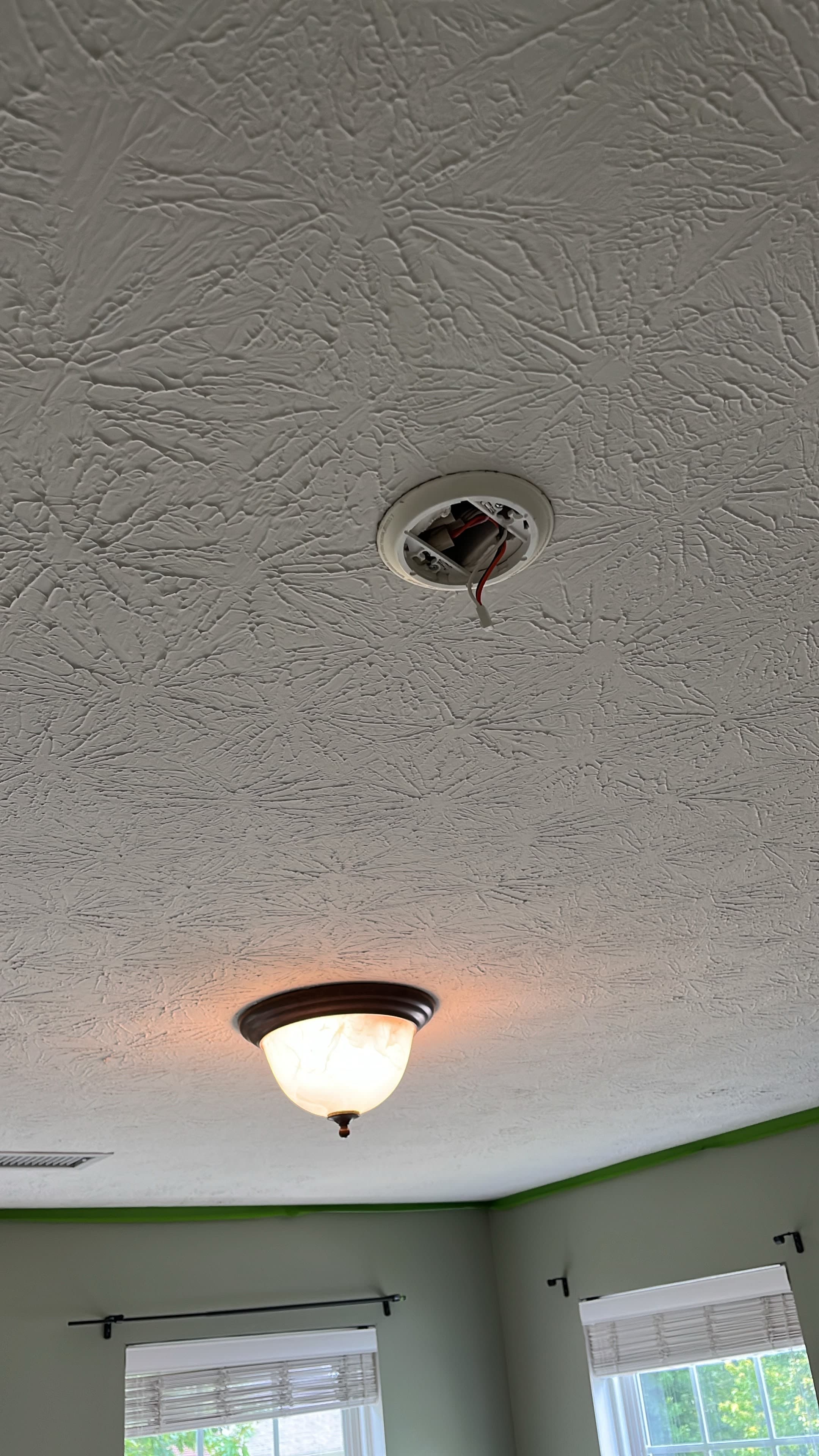 Before: a dated stomped-texture ceiling with an exposed light-fixture box, ready for removal