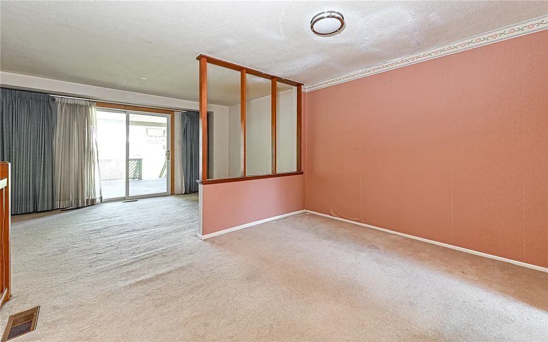 Moon Township living room before remodel with old carpet, pink walls, and a walled-off layout