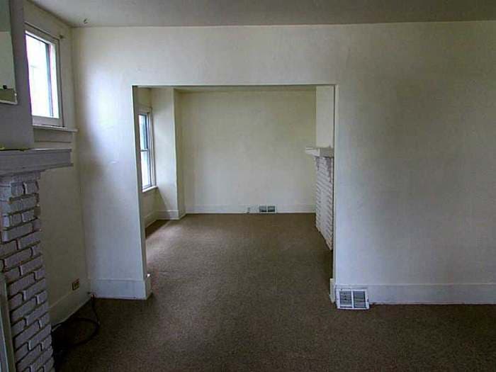 Carpeted room opening into a second room before renovation