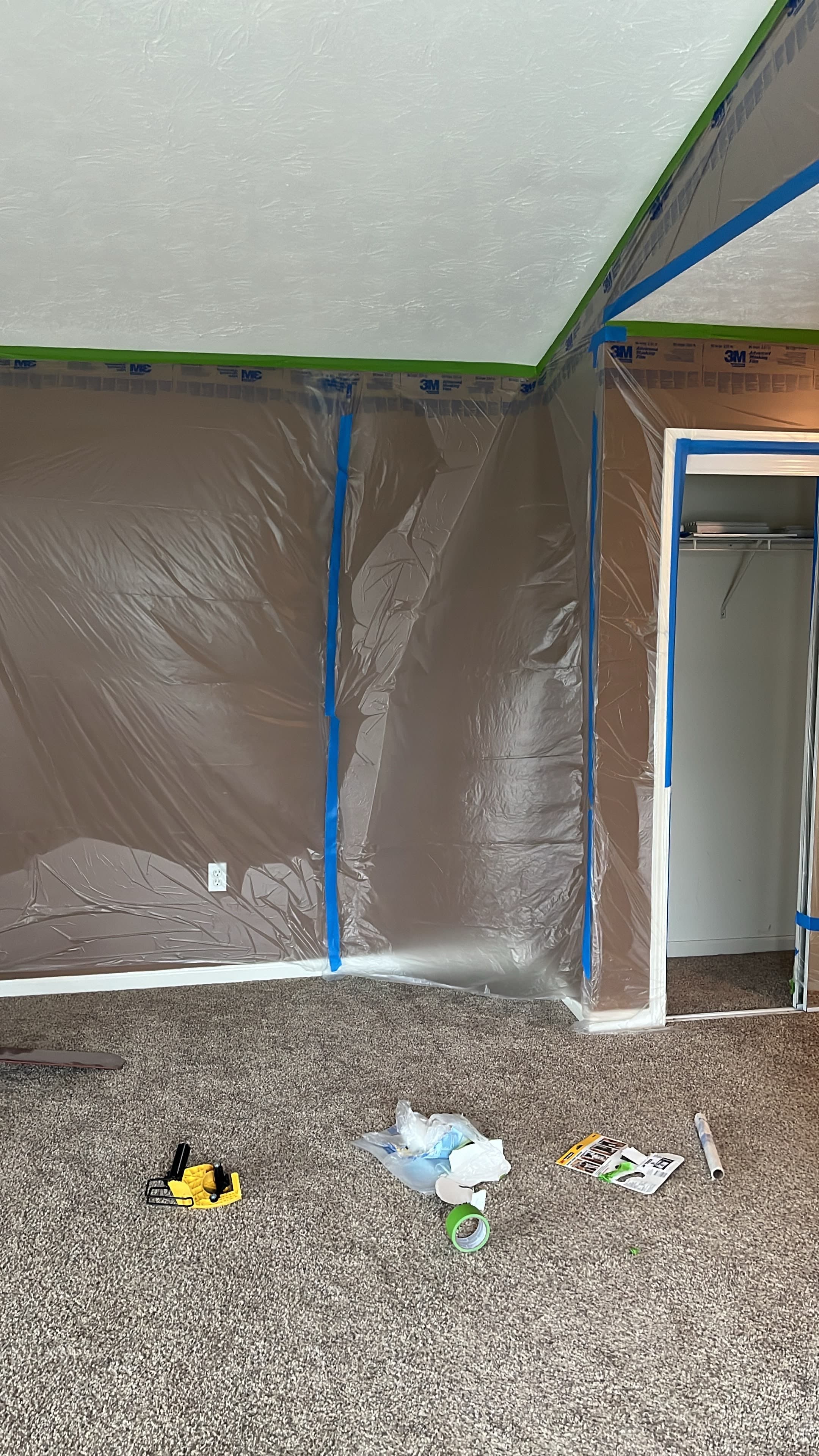 Bedroom walls and closet fully masked with plastic and painter's tape before texture removal and painting